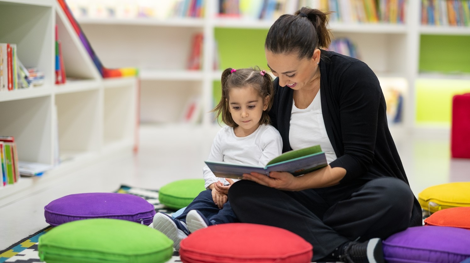 Mother and daughter are reading books in the nursery
