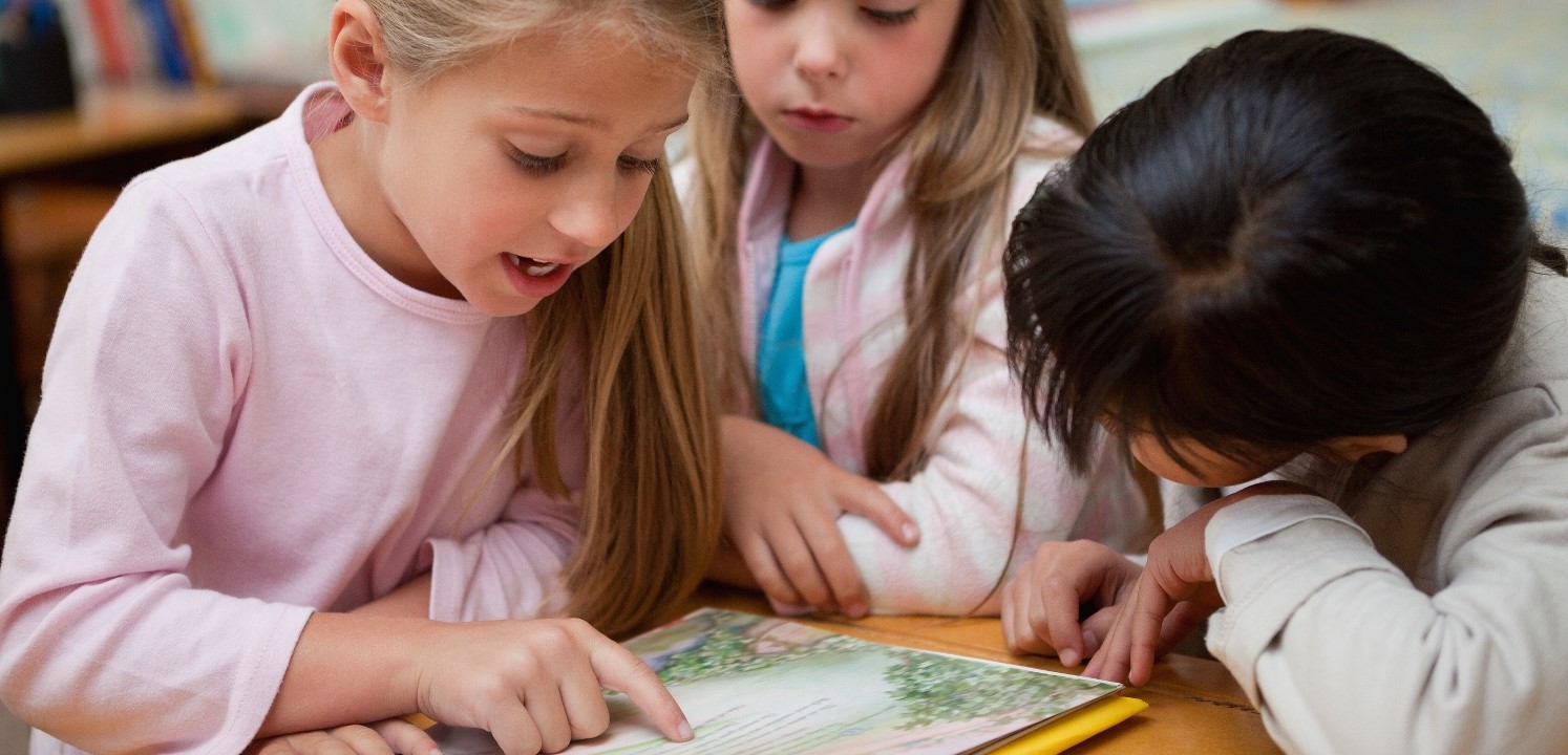 Schoolgirls,Reading,A,Fairy,Tale,Together,In,A,Classroom